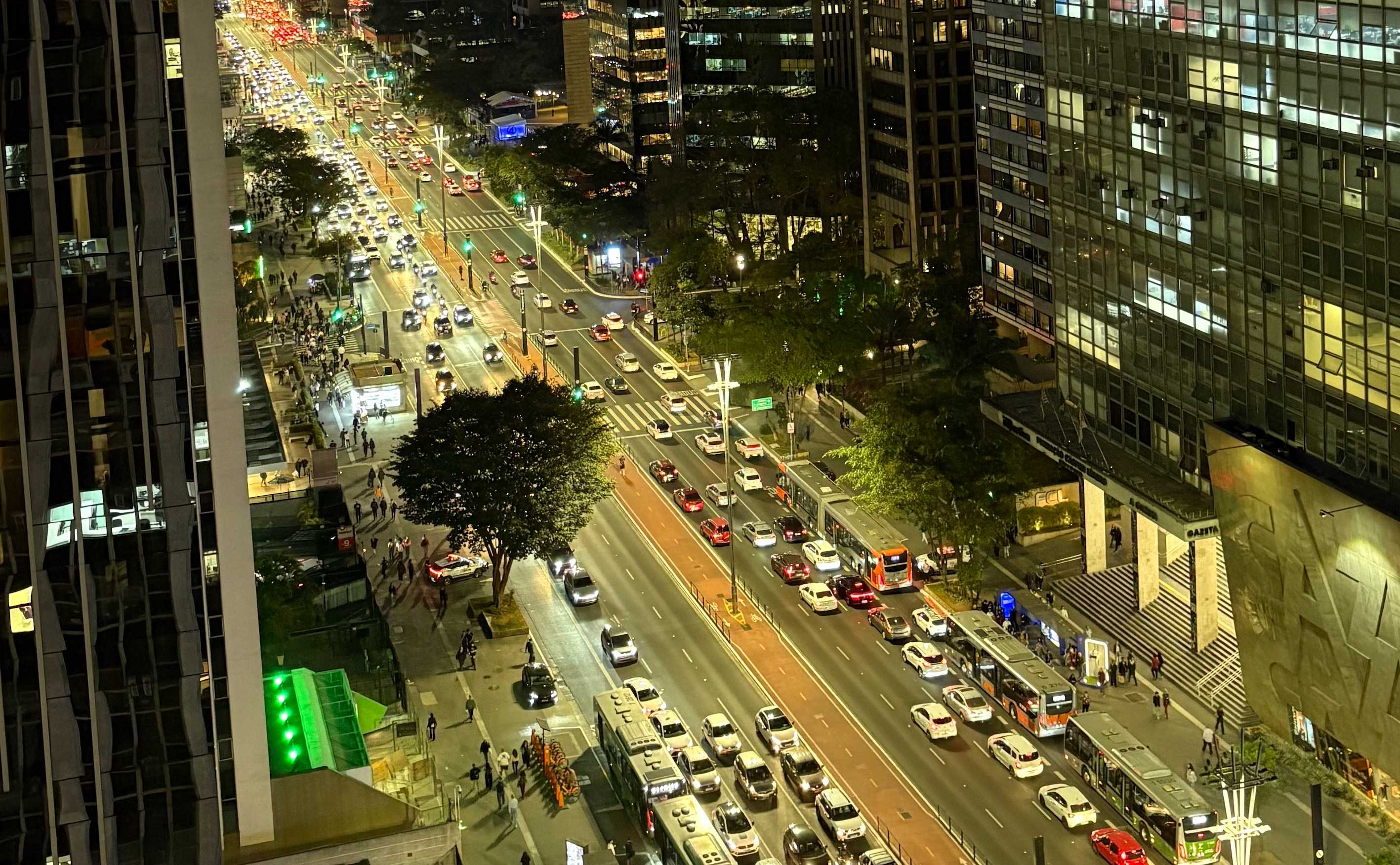 Vista noturna da Avenida Paulista com movimento intenso